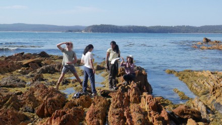 Students out on a rock during a field trip