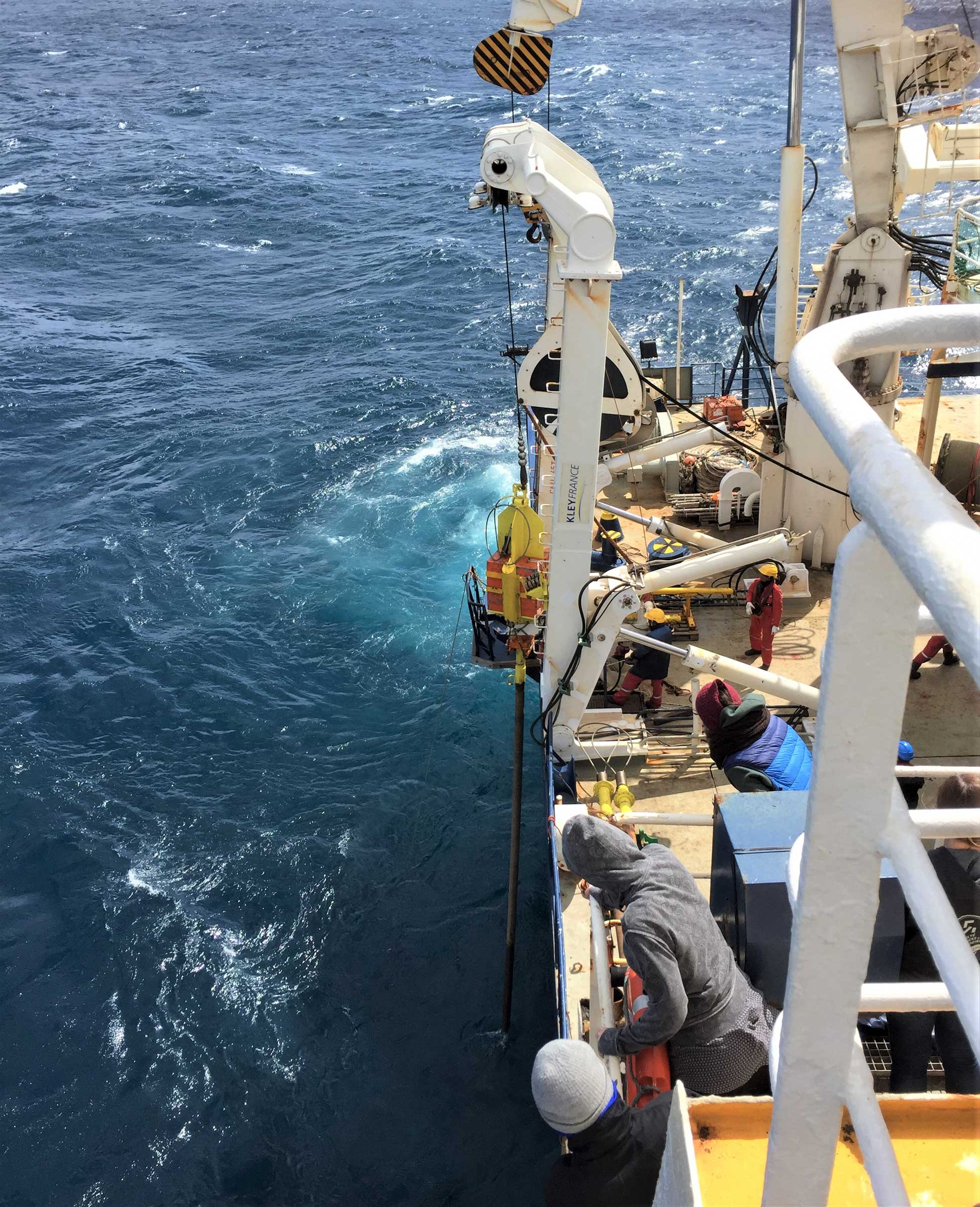Scientists gather to watch a 60m long CALYPSO core being retrieved onboard the R/V Marion Dufresne II. Credit: Kelly Lawler