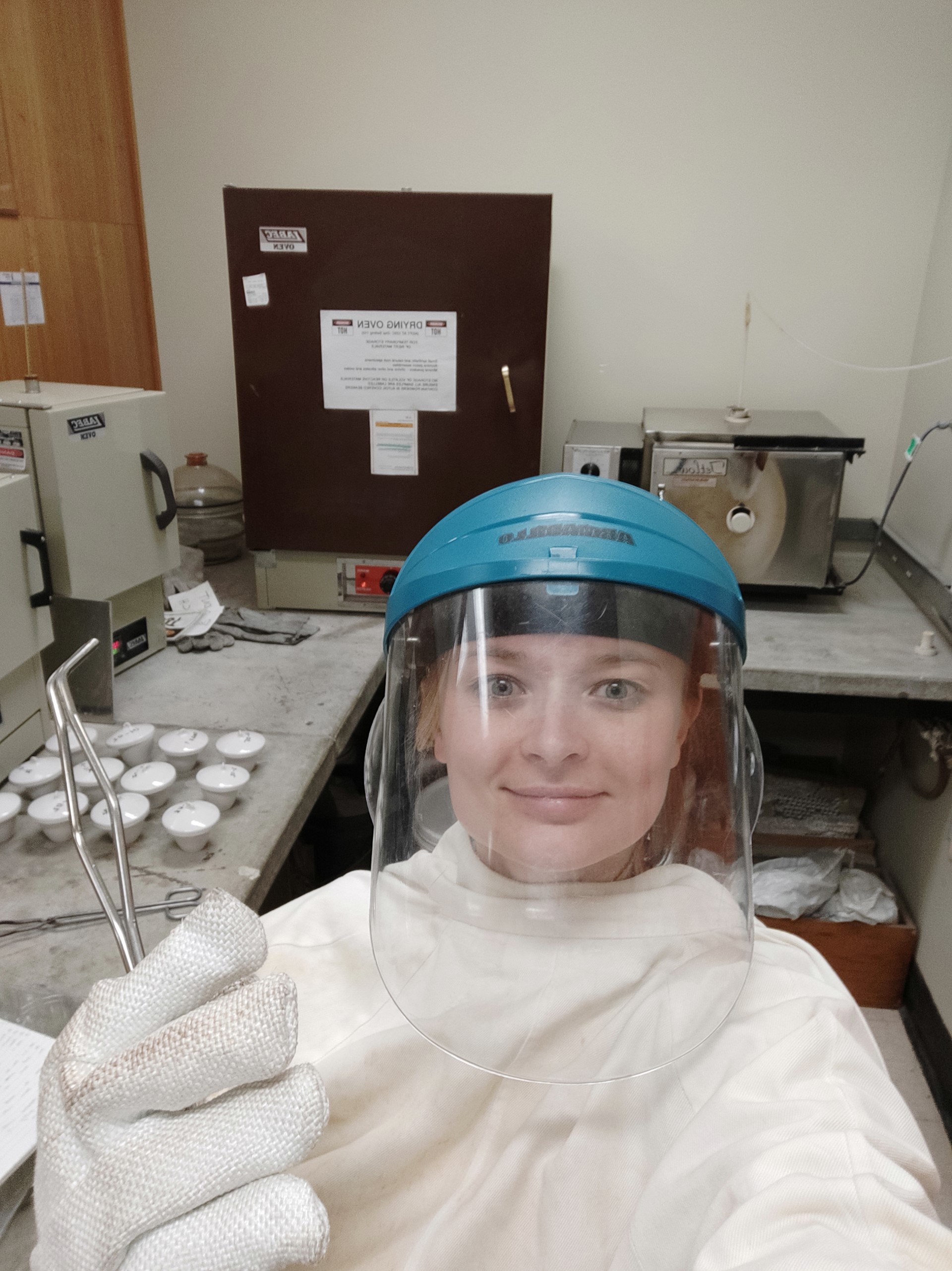 A woman wearing protective gear in a lab setting
