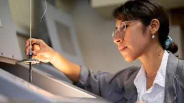 Dr Ana Casas Ramos focuses on a furnace as she creates a mock volcanic reaction in the lab